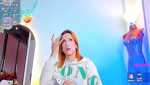 Redheaded girl shows off her ass in front of a porn poster